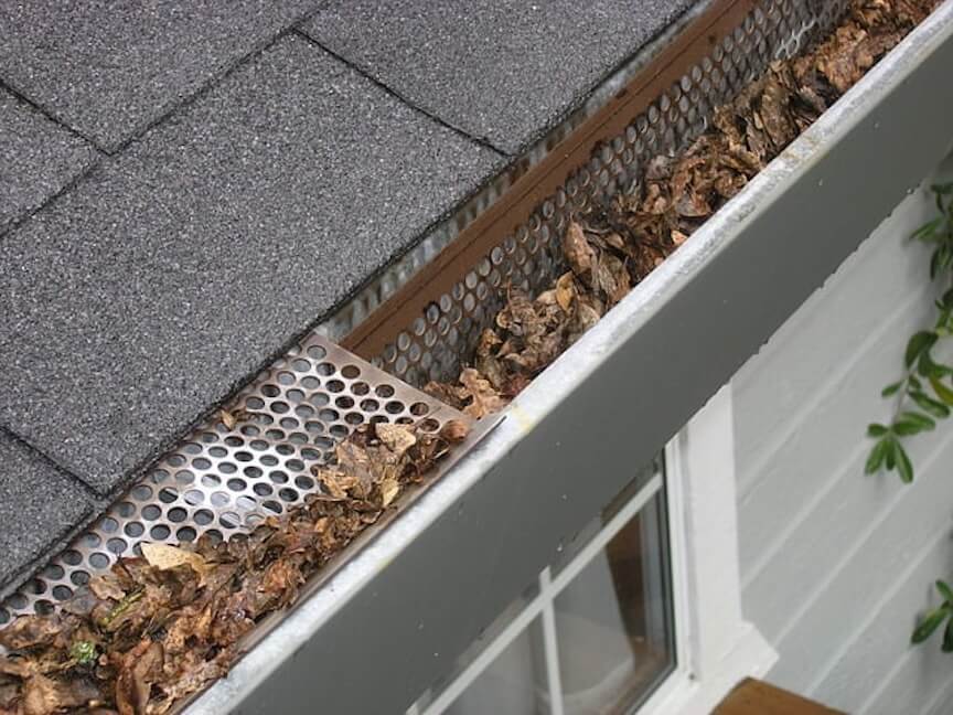 A gutter filled with leaves and debris
