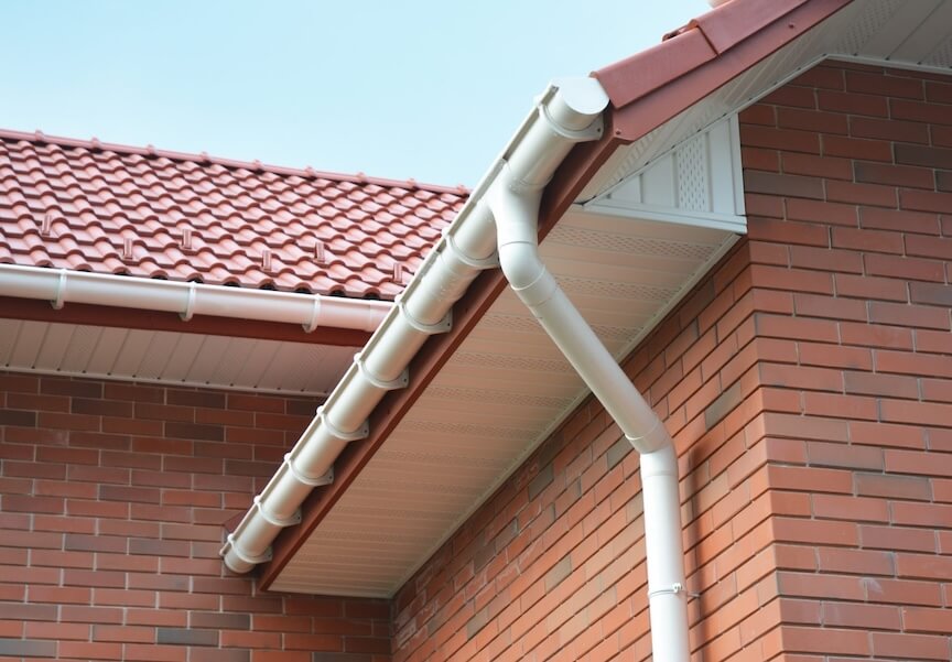 Professional technician installing gutter guards with proper tools and safety equipment