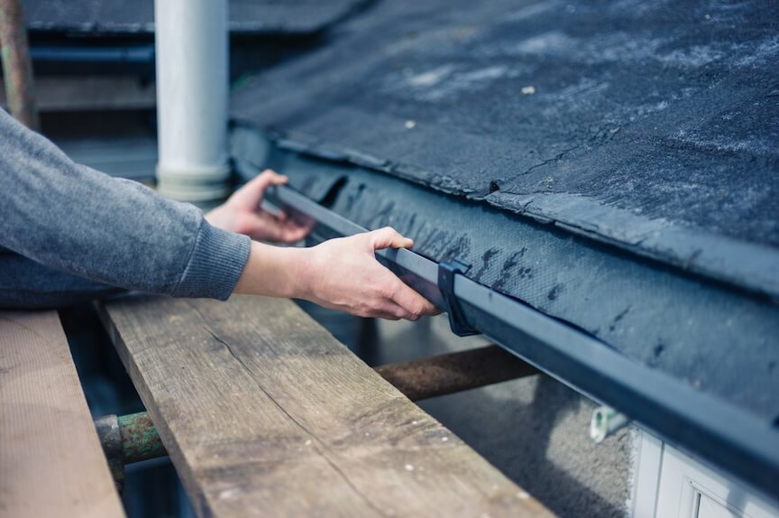 A person installing a gutter system